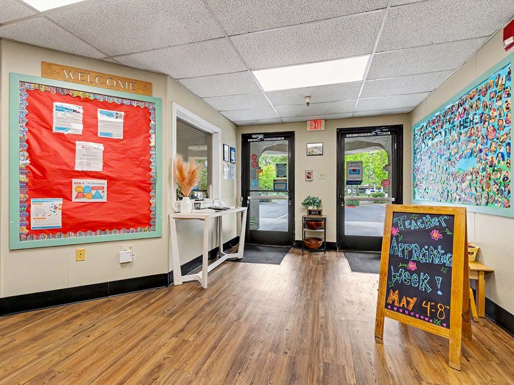 Entrance area with a welcome sign and a chalkboard sign for "Teacher Appreciation Week"