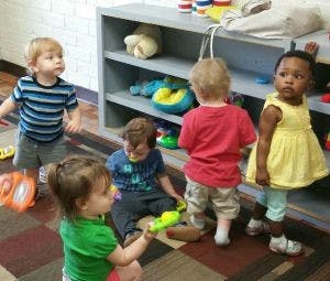 Four children playing with toys in a room