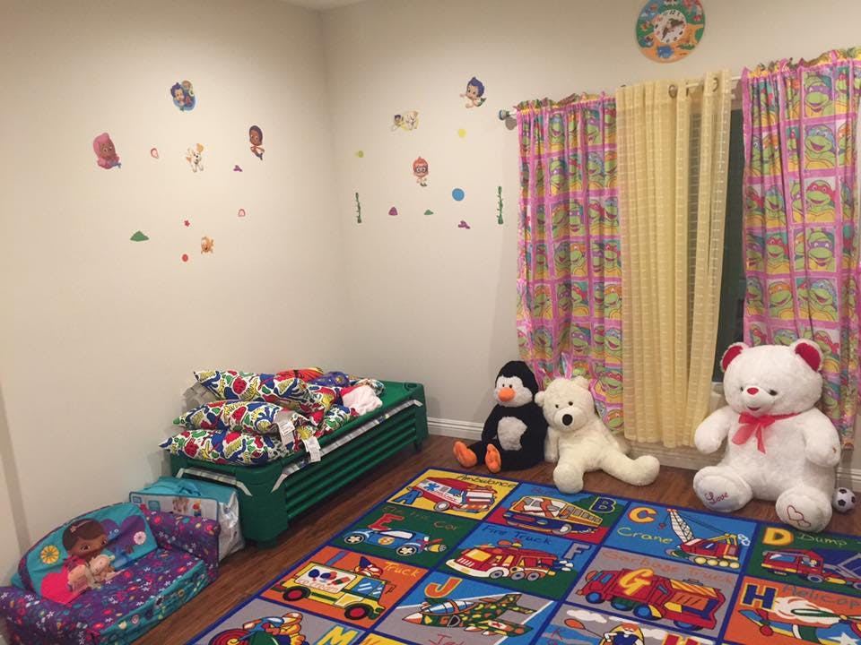Child's room with a bed, stuffed animals, and a colorful rug