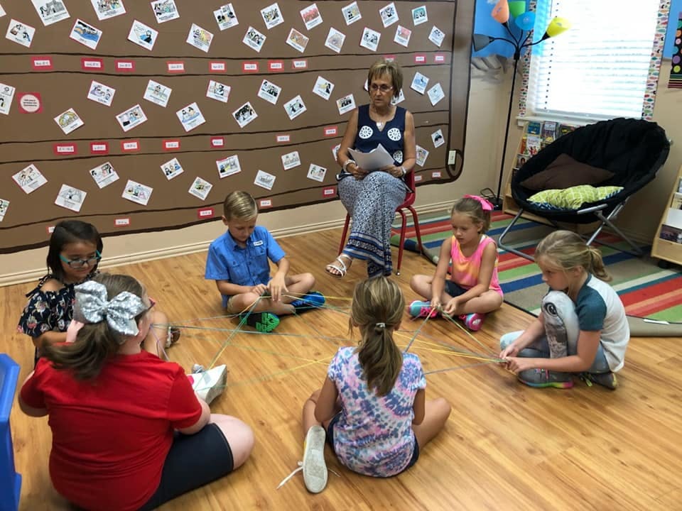 Adult reading to children sitting on the floor in a classroom