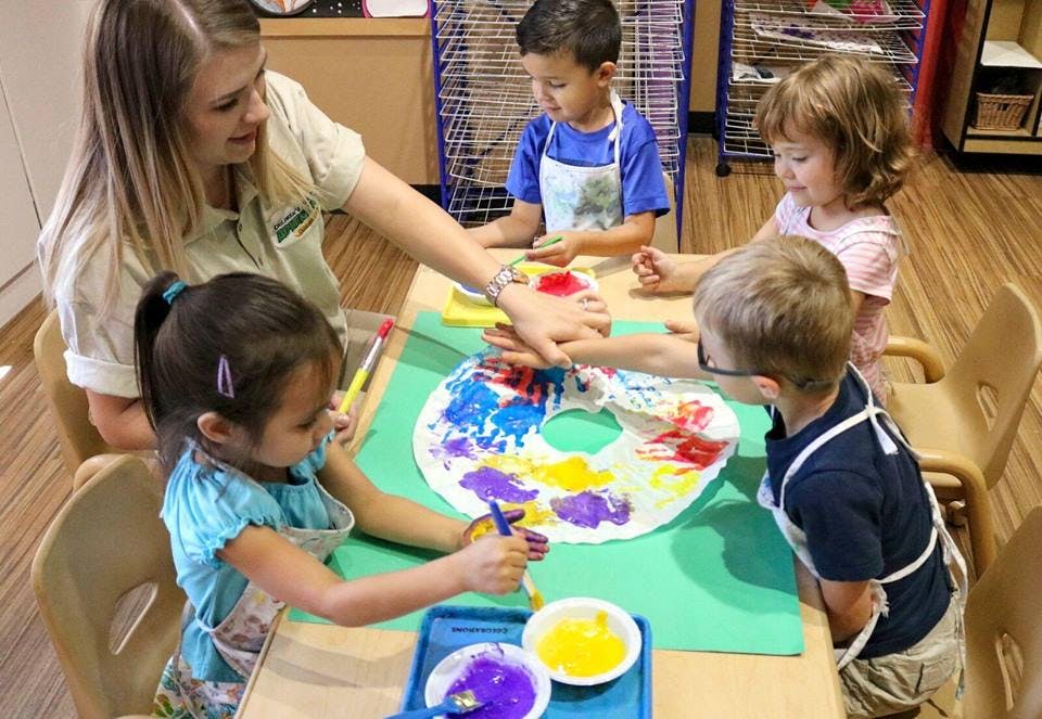 Adult and children painting together at a table