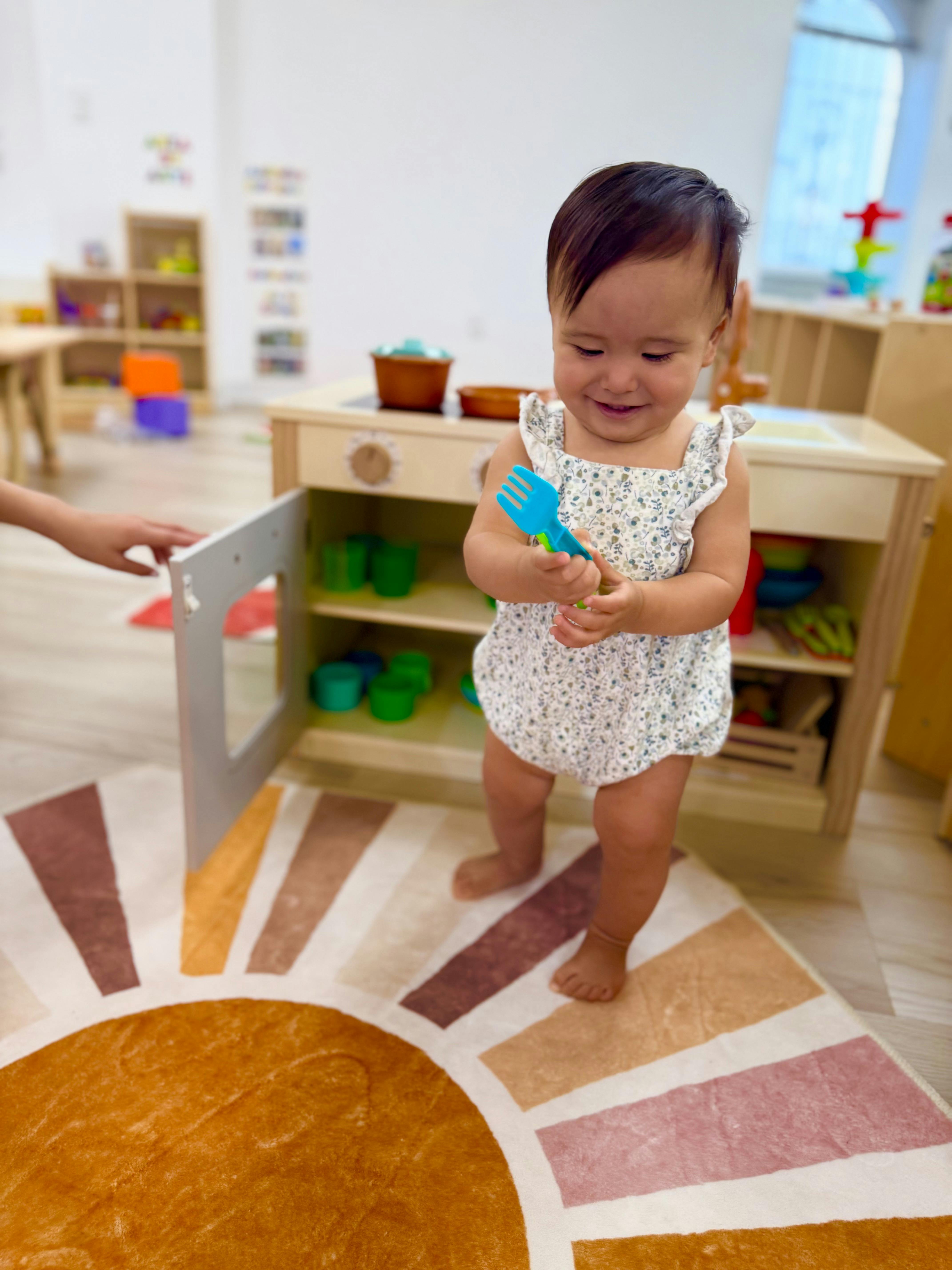 Child standing on a rug holding a toy fork