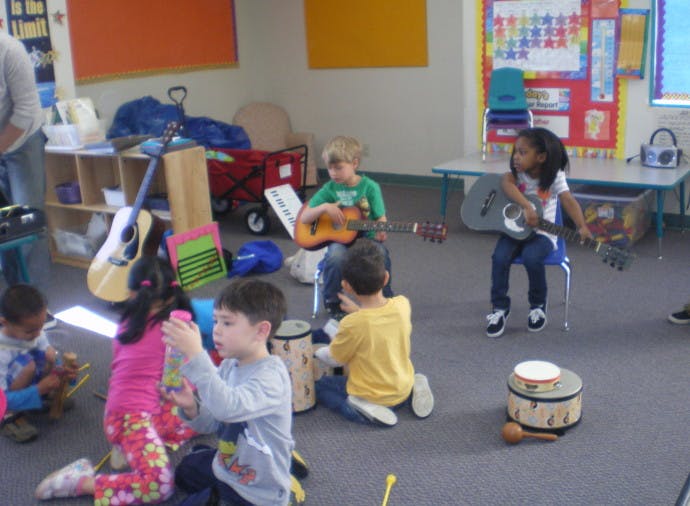 Children playing musical instruments in a classroom