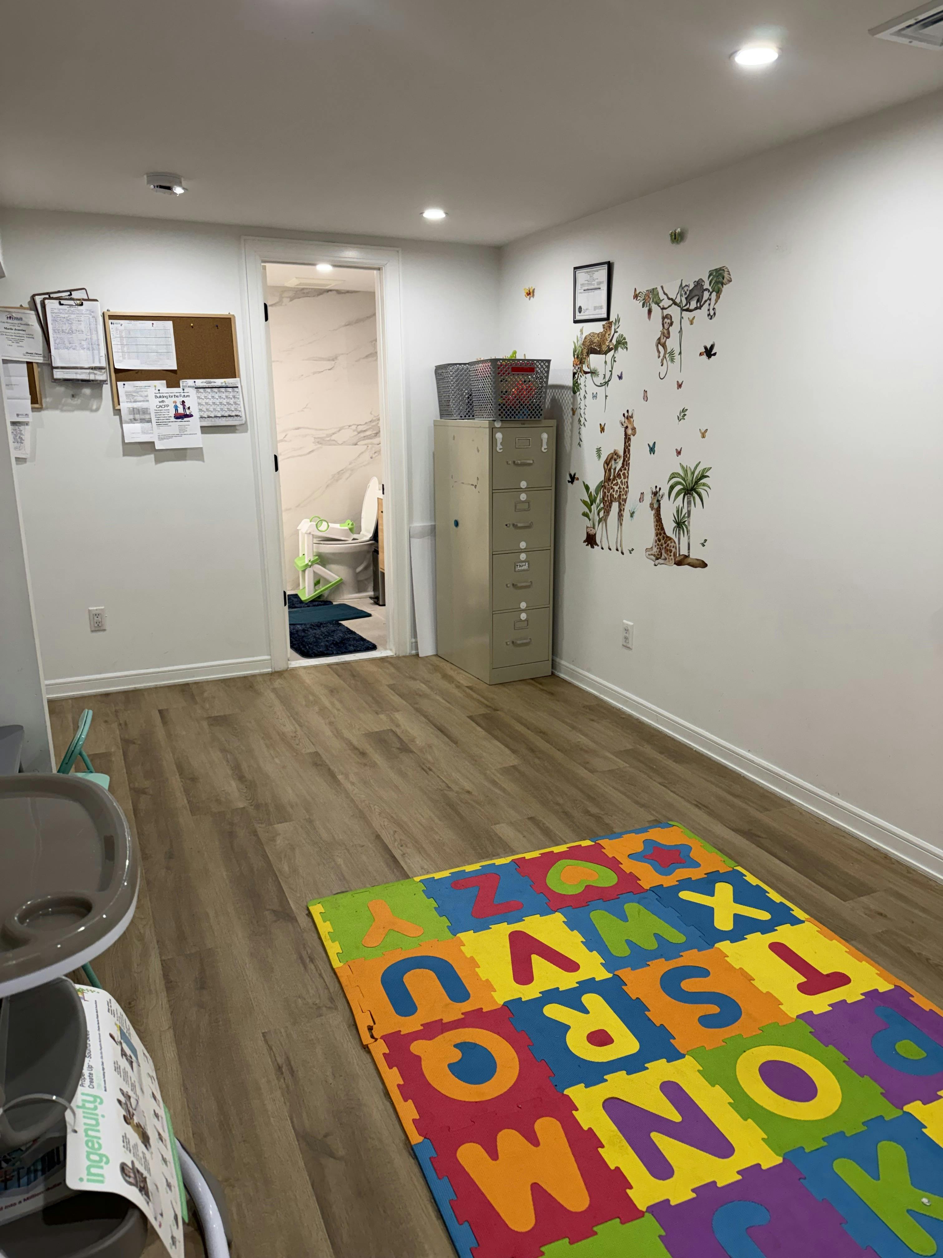 Childcare room with alphabet floor mat and animal wall decals