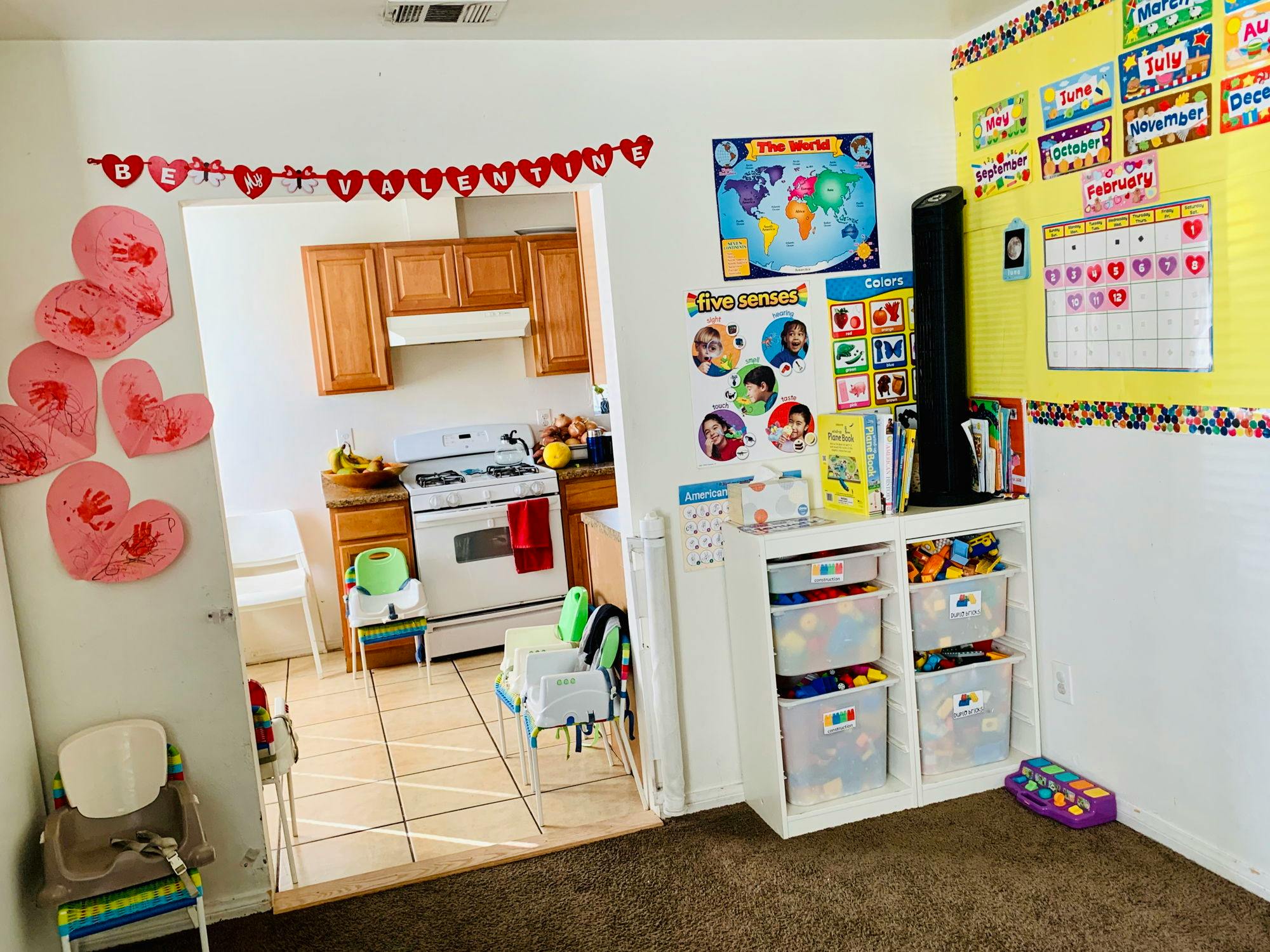 Kitchen with a stove and cabinets, seen through a doorway decorated with hearts