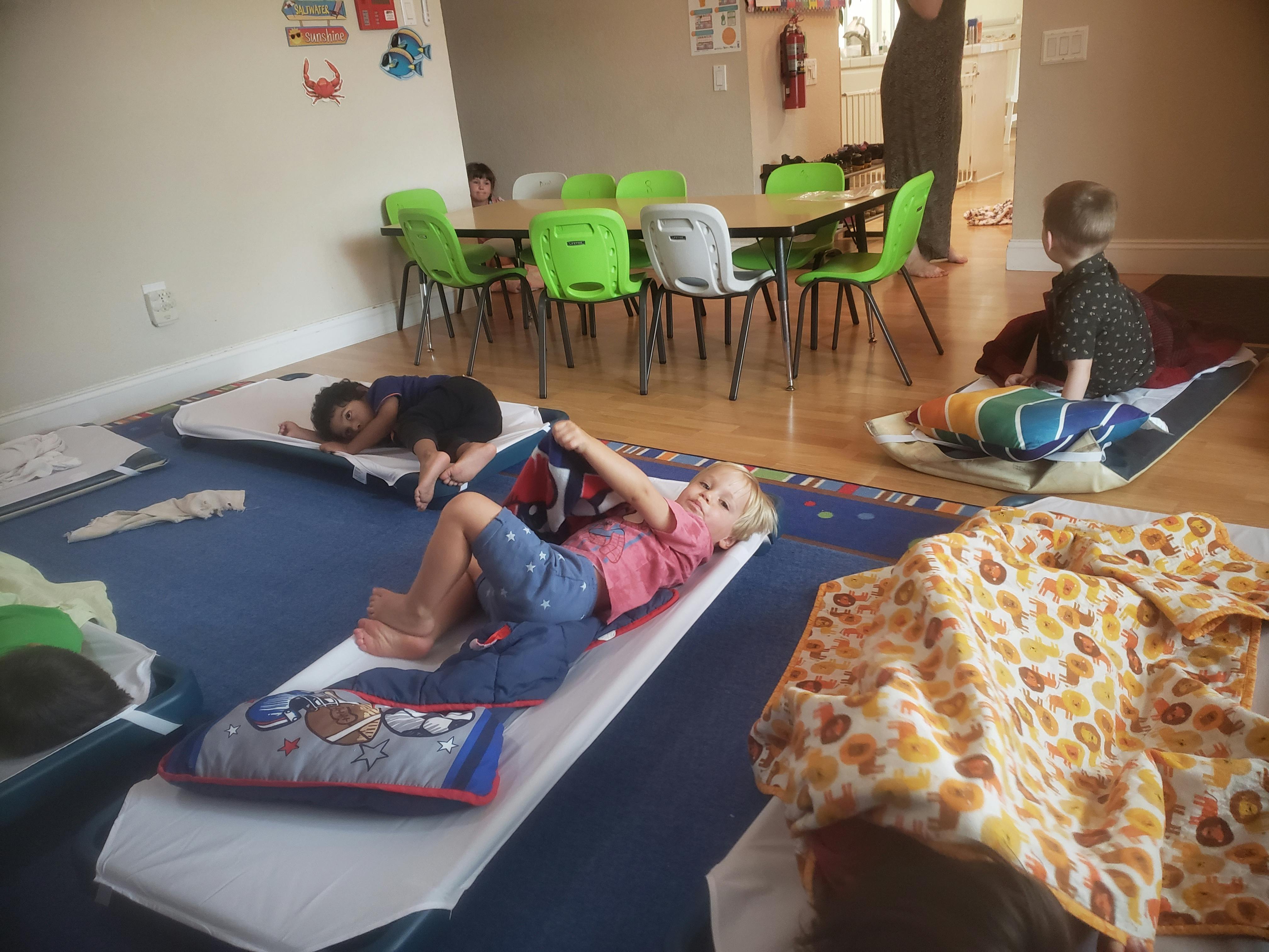 Children resting on mats in a room