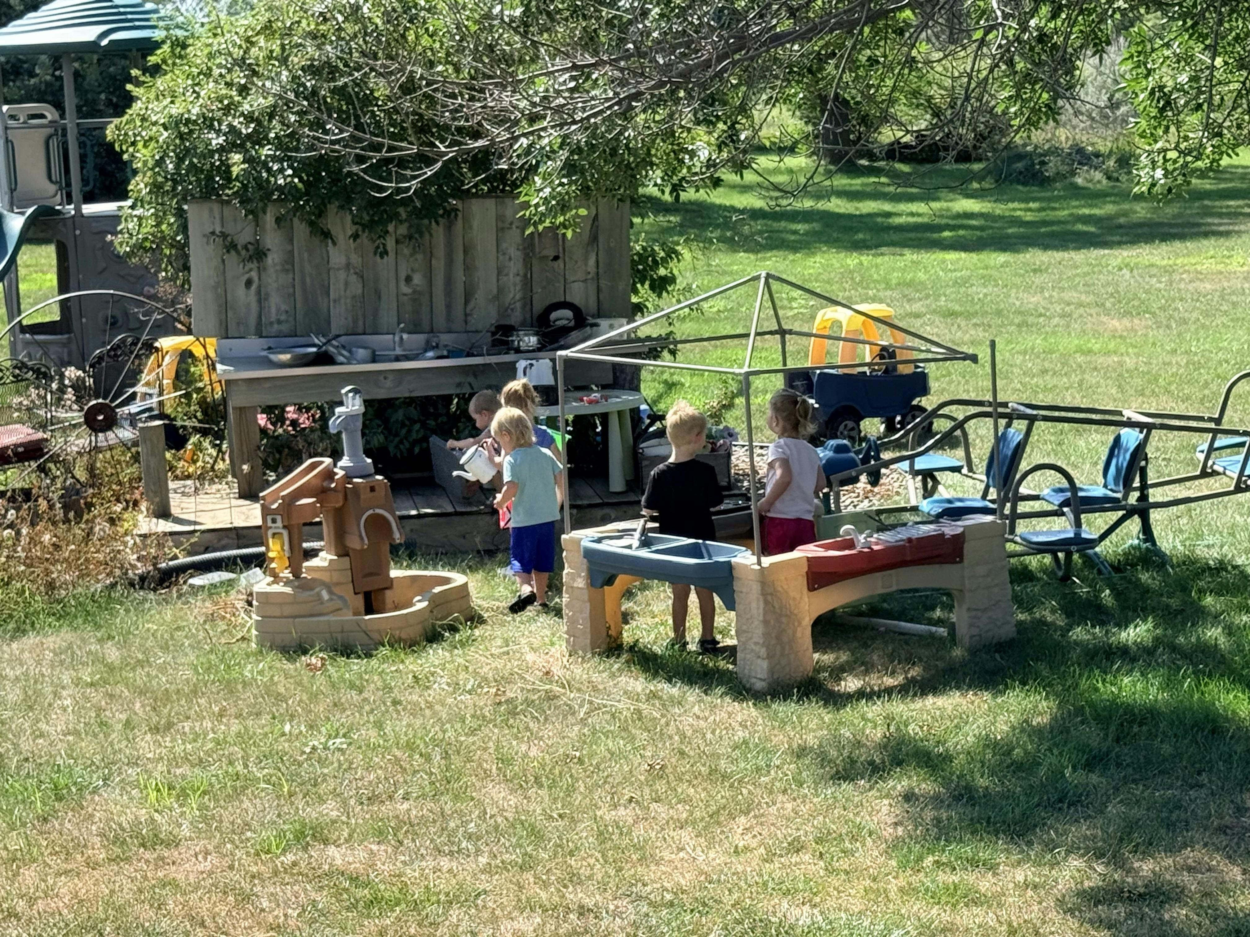 Children playing with outdoor toys in a grassy yard