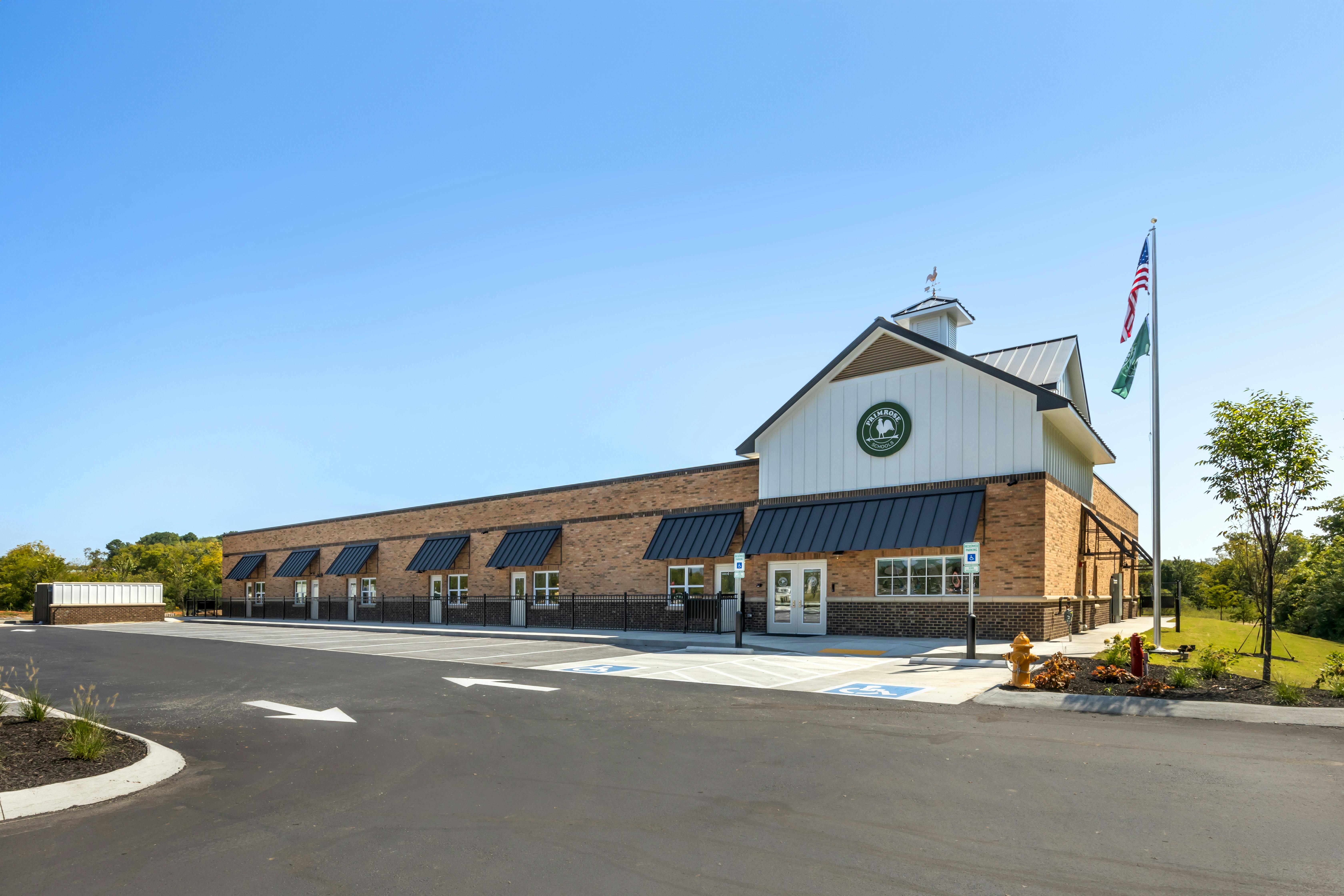 A Primrose Schools building with a barn-like facade and brick walls