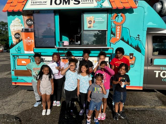 Group of children standing in front of a food truck