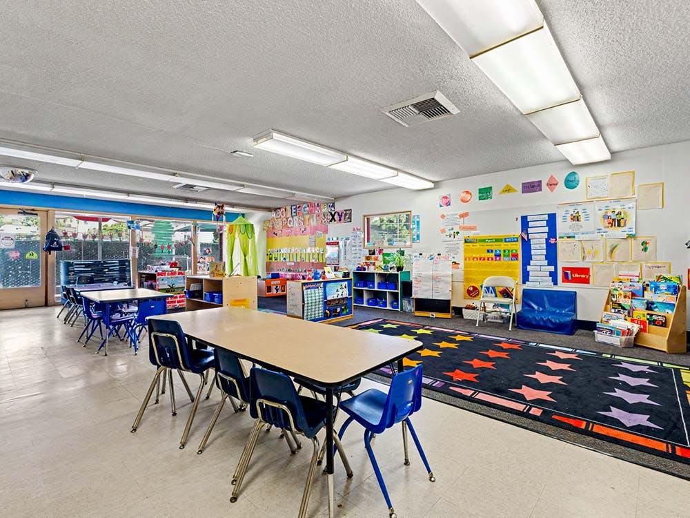 Classroom with small tables and chairs, and colorful decorations