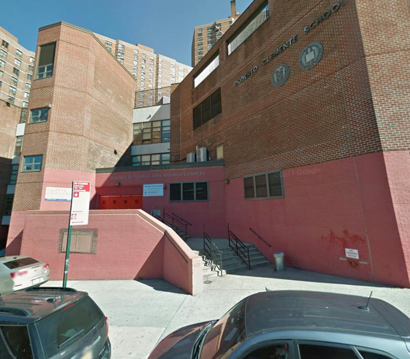 Exterior of a brick building with a red base and stairs leading up