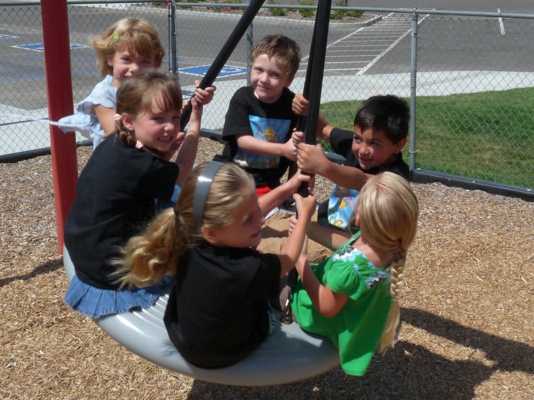 Children playing on a tire swing at a playground