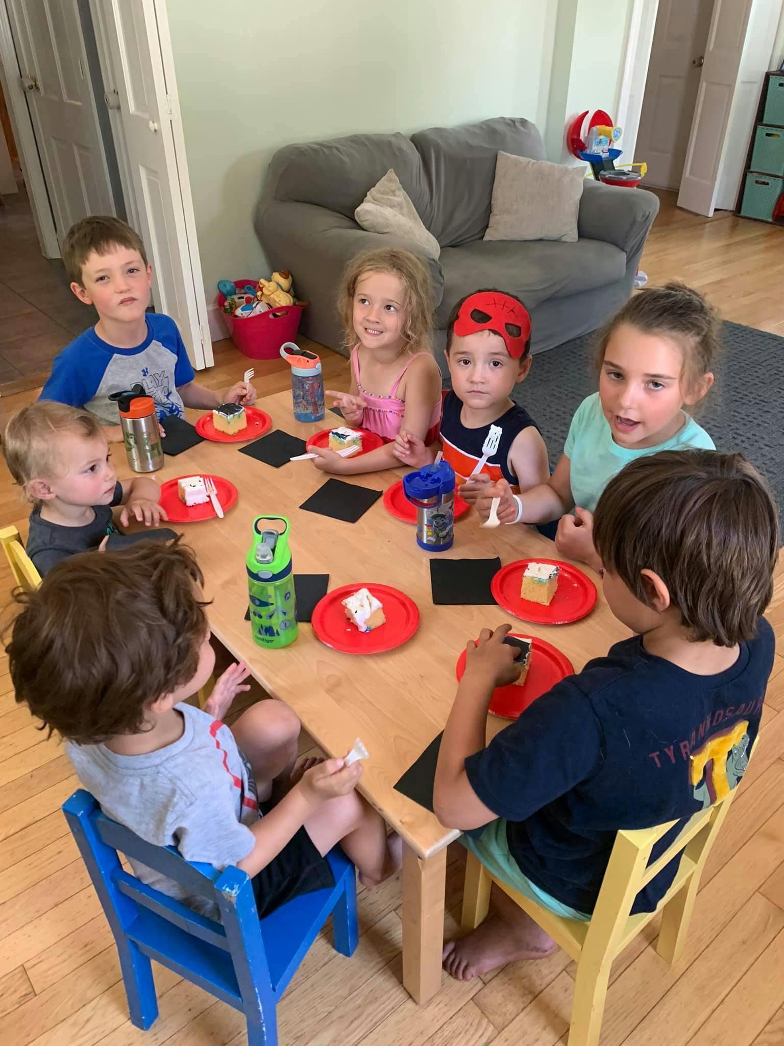 Children sitting around a table eating cake