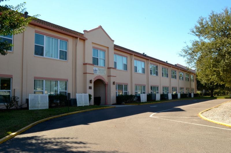 Exterior of a building with multiple windows and an arched entrance