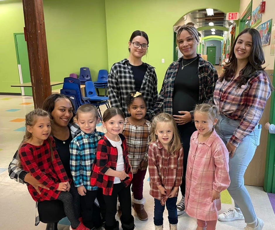 Three people and seven children posing for a photo indoors group photo