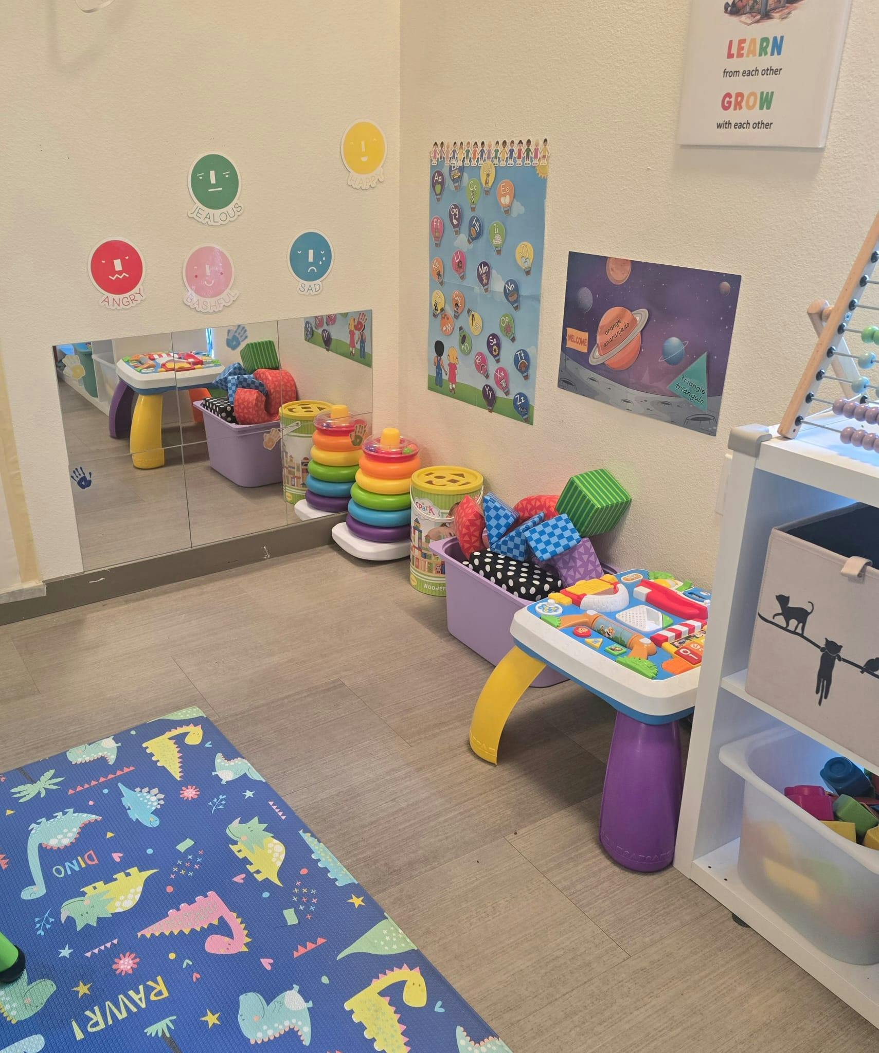 Playroom with toys, a mirror, and posters on the wall
