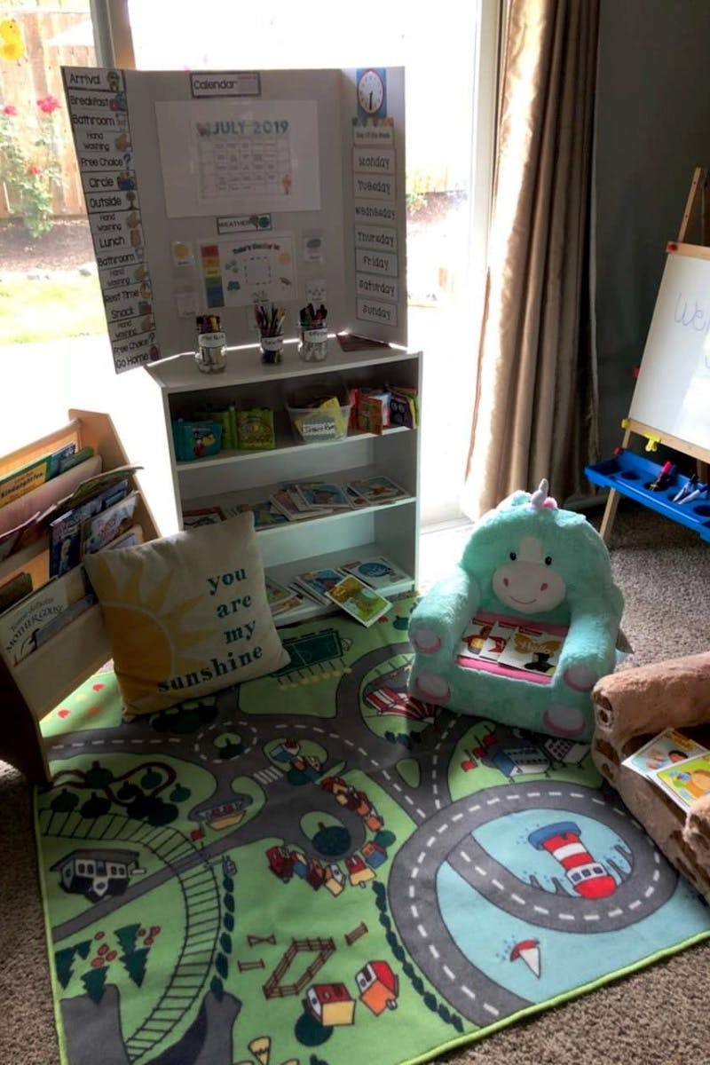 Children's play area with a road map rug, bookshelf, and unicorn chair