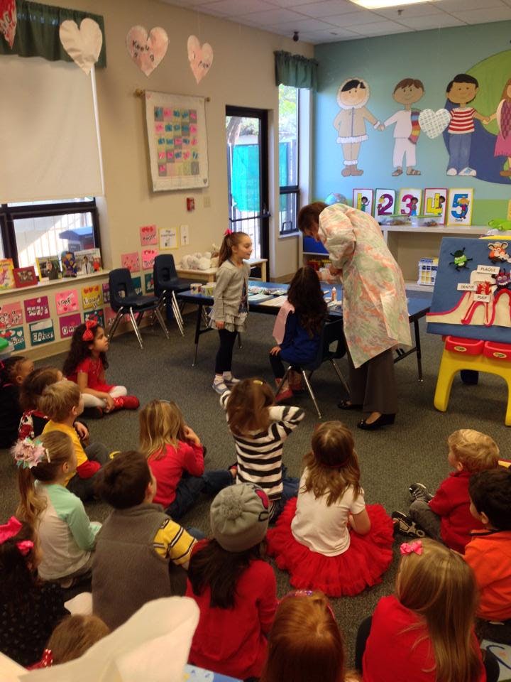 Adult interacting with children in a classroom