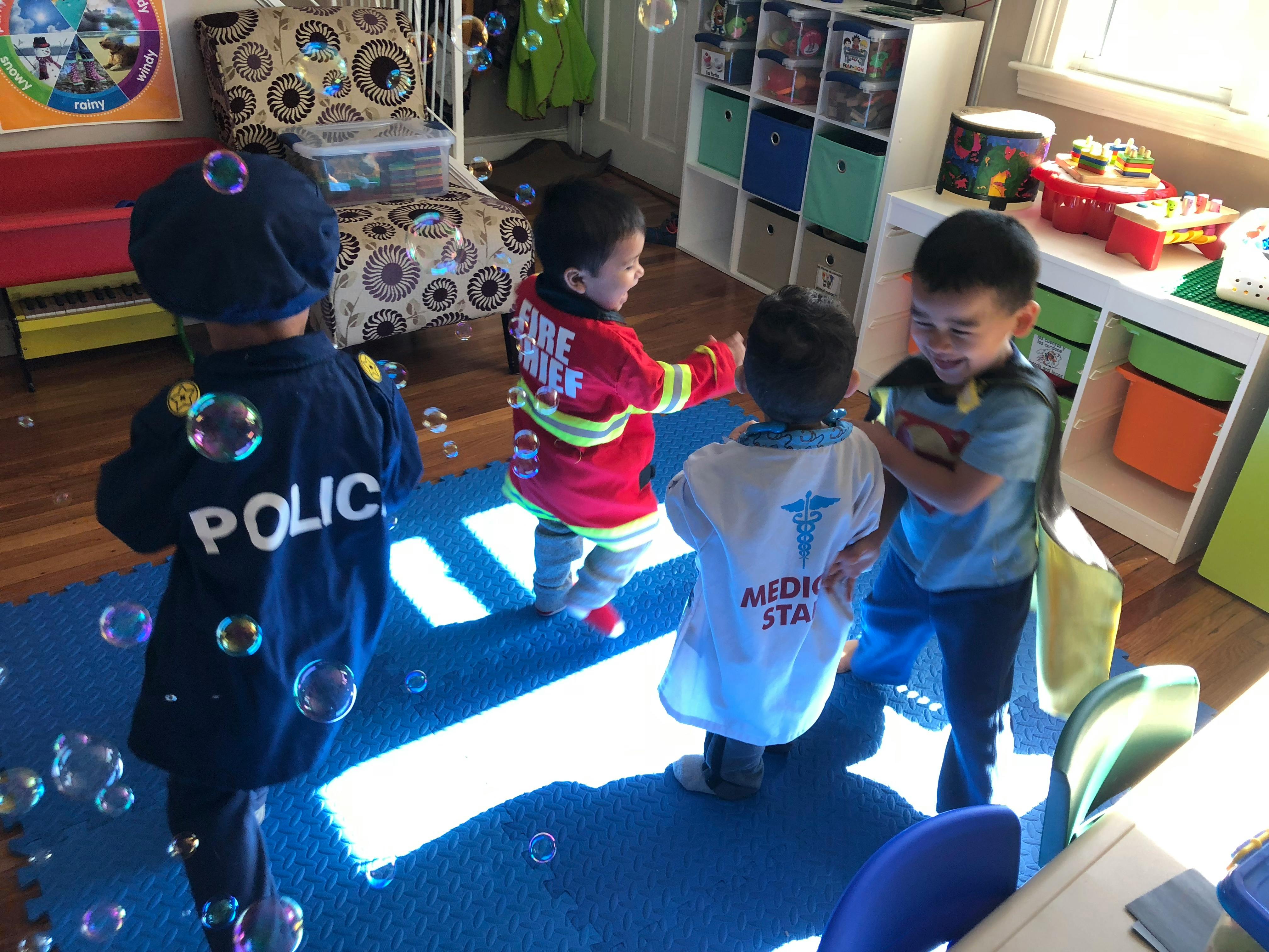 Children in costumes playing with bubbles in a room