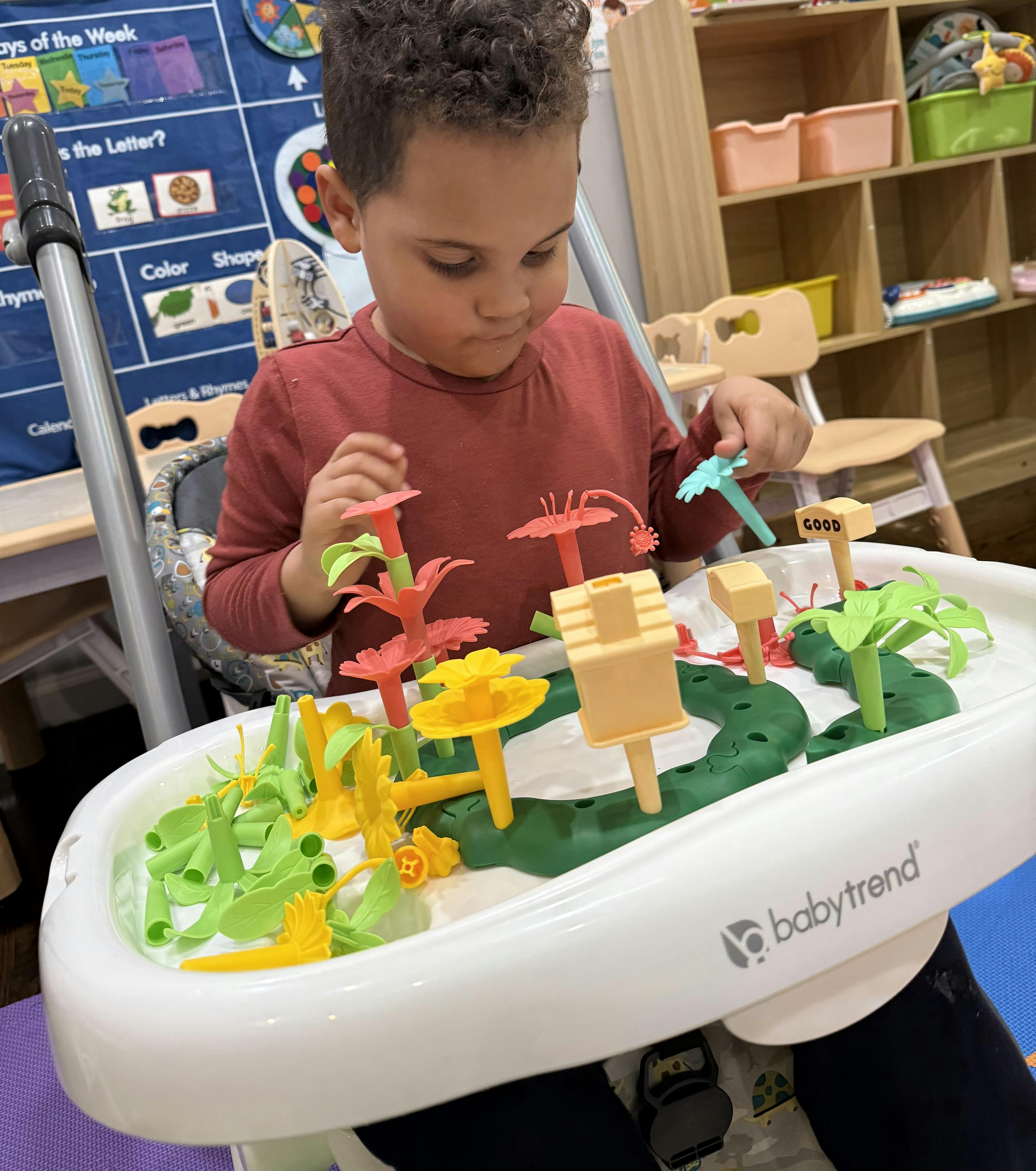 Child playing with a toy on a high chair tray