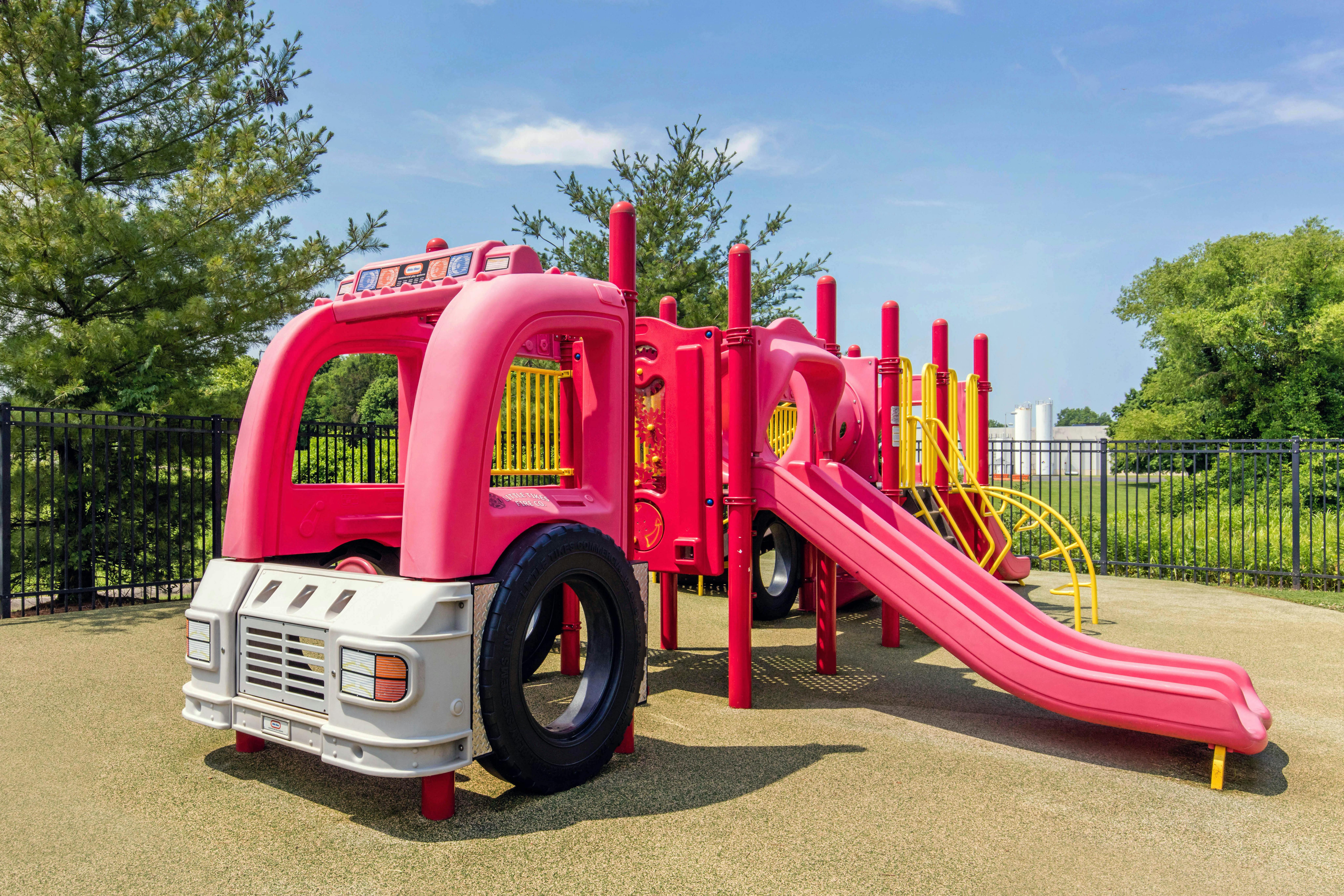 Playground equipment shaped like a fire truck with slides and climbing areas