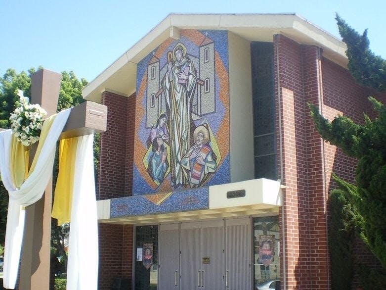 Church facade with a mosaic of a saint and other figures above the entrance