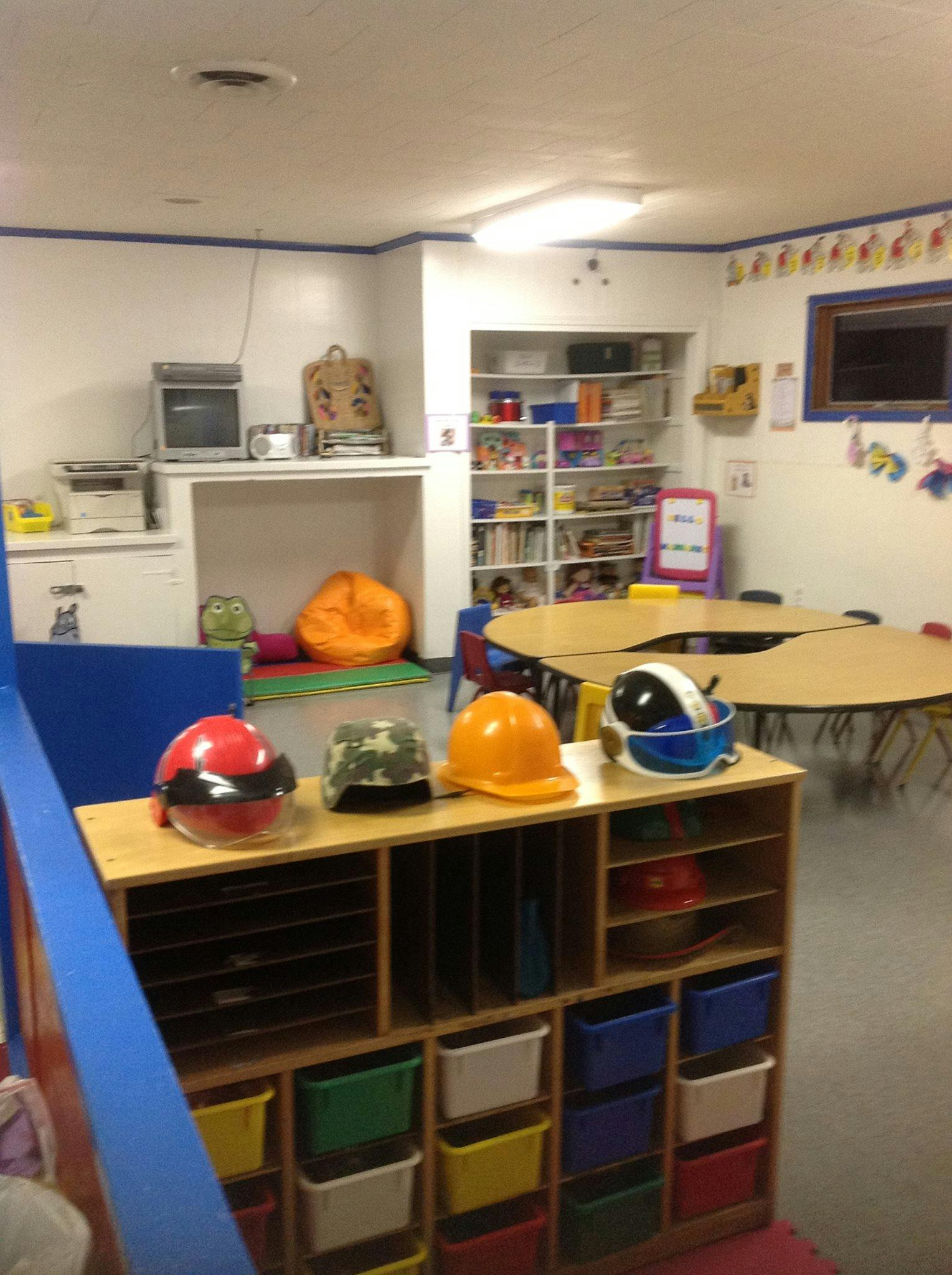 Playroom with dress-up hats on a shelf and tables in the background