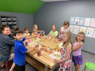 Adult and children gathered around a table doing crafts