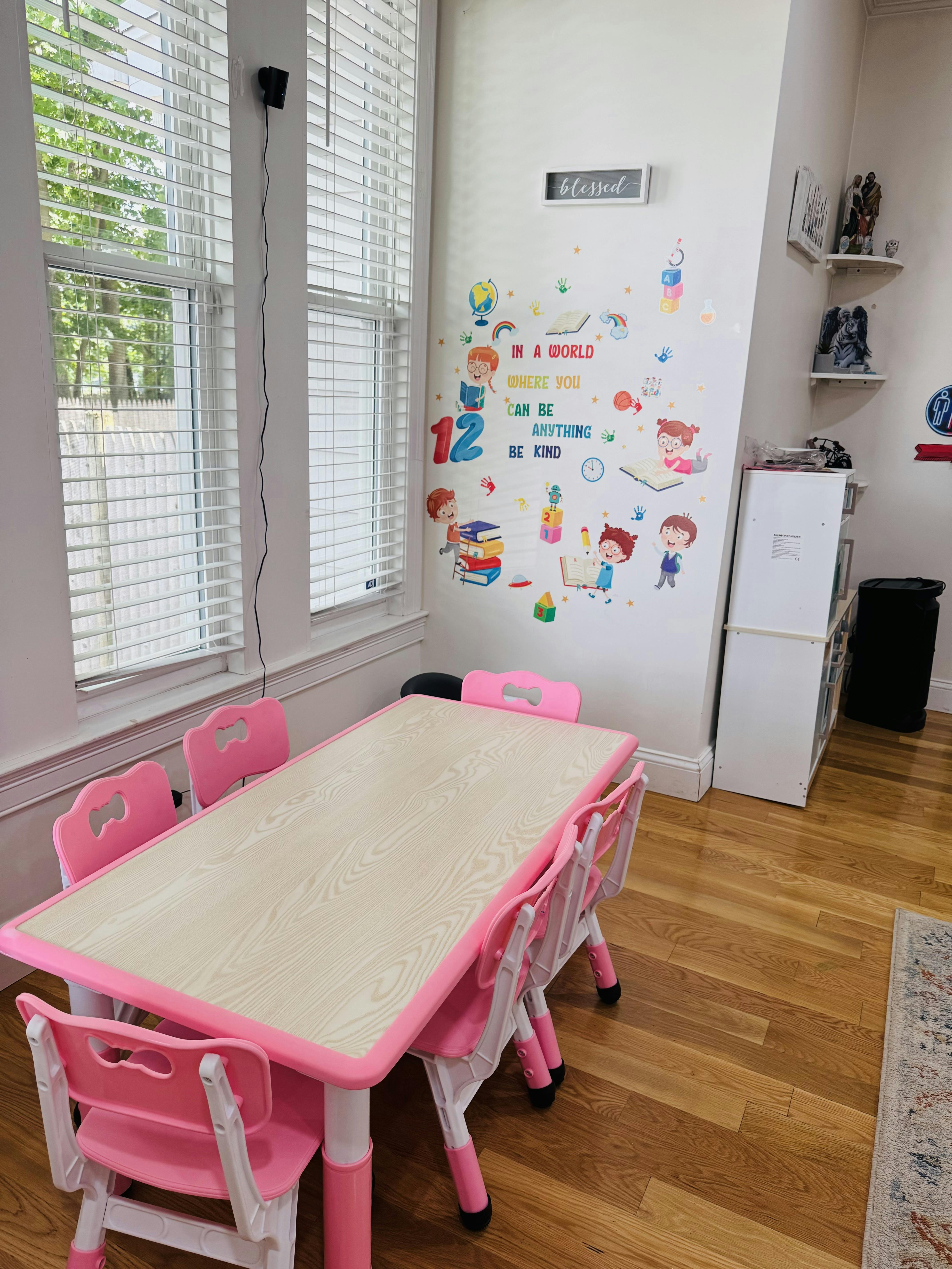 Children's table and chairs in a room with wall decals