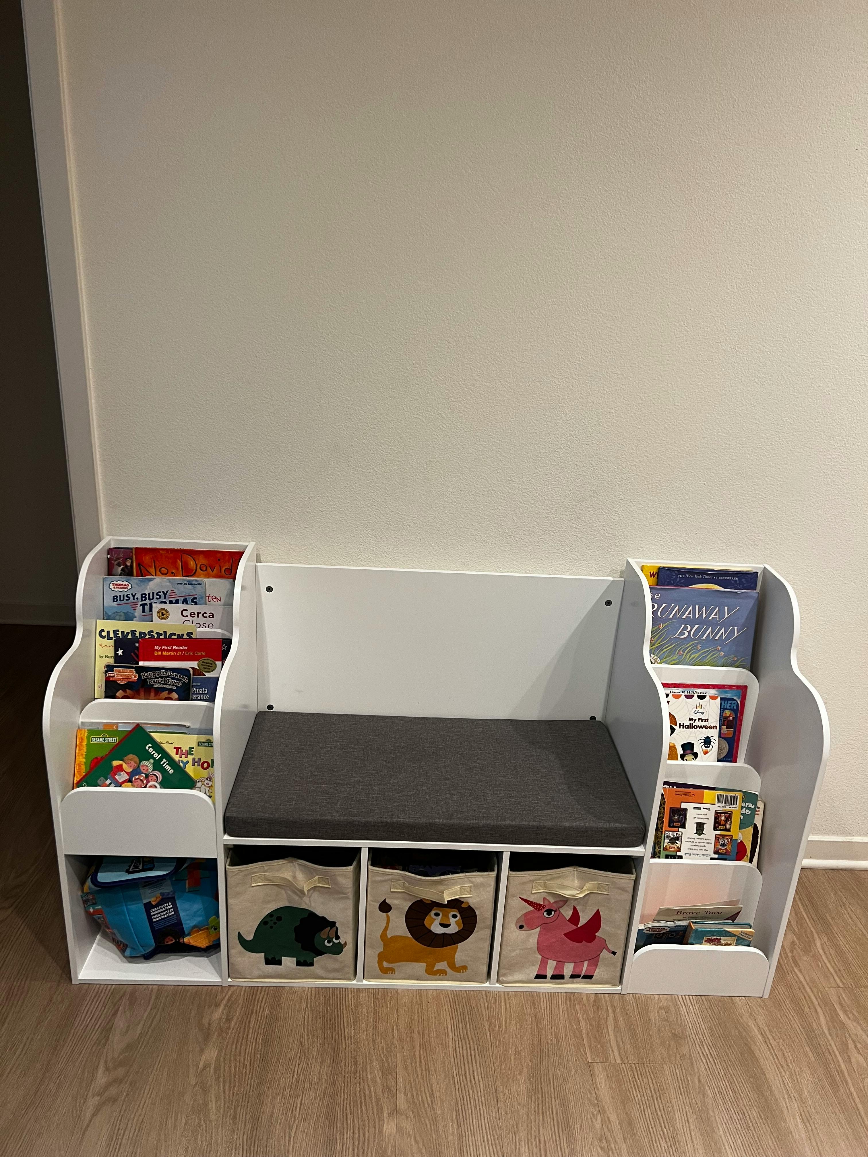 White children's reading bench with books and toy bins