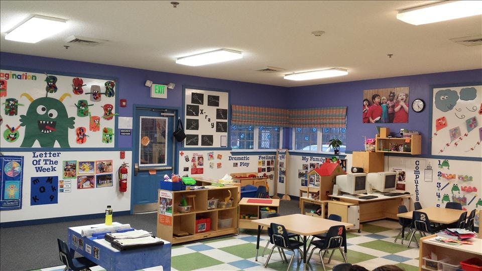 Classroom with tables, chairs, computers, and colorful decorations