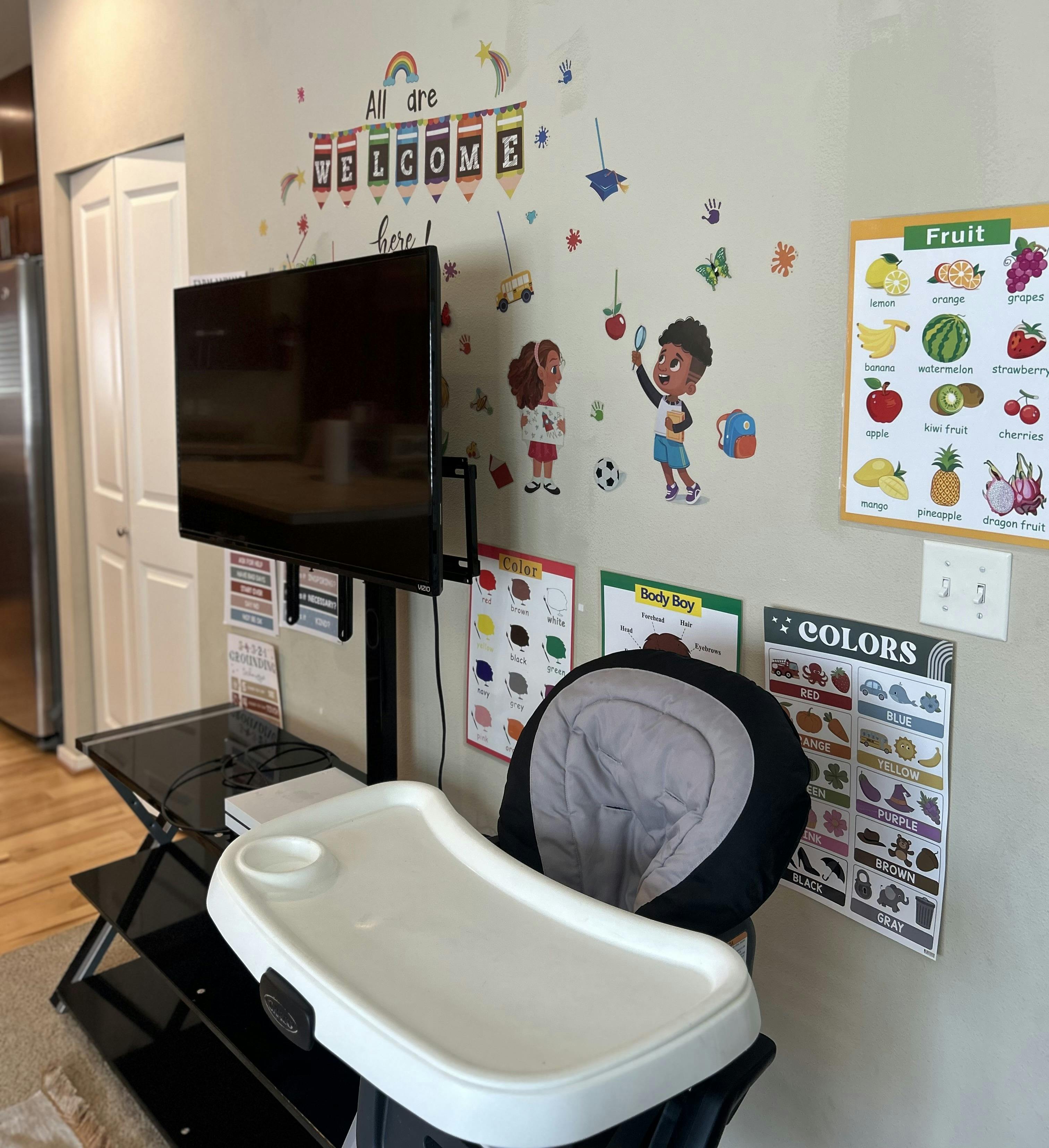 High chair in front of a wall with educational posters and decorations