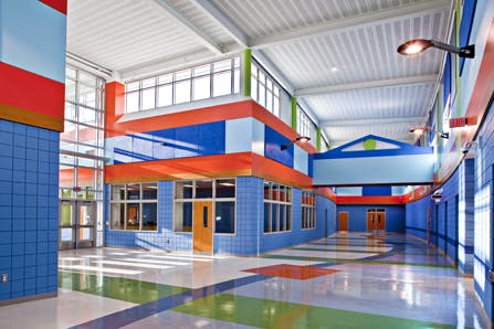 Colorful school hallway with blue, orange, and green walls and floor patterns on the floor