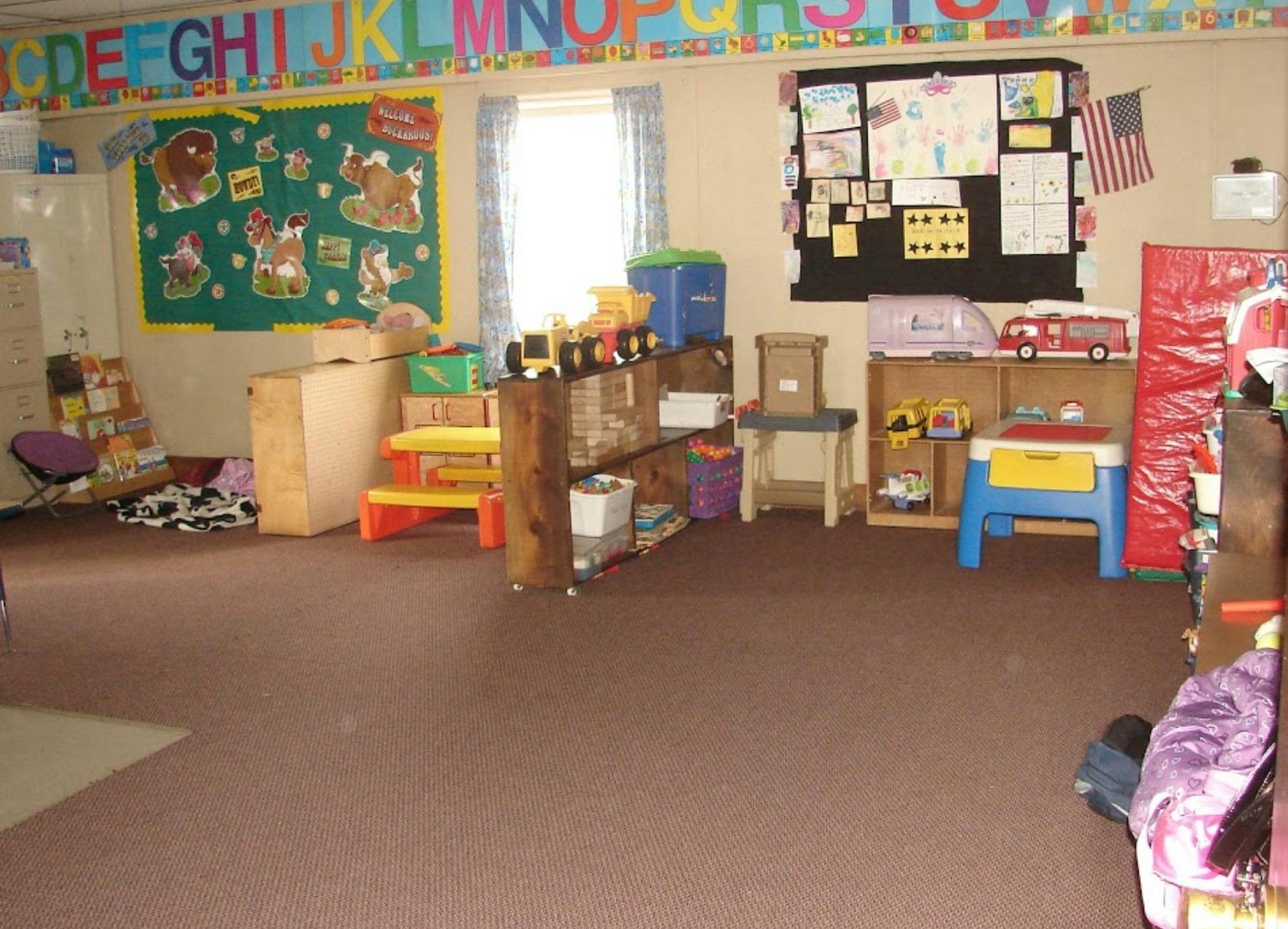 Classroom with toys, shelves, and bulletin boards