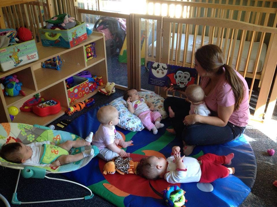 Adult with multiple babies and infants in a play area