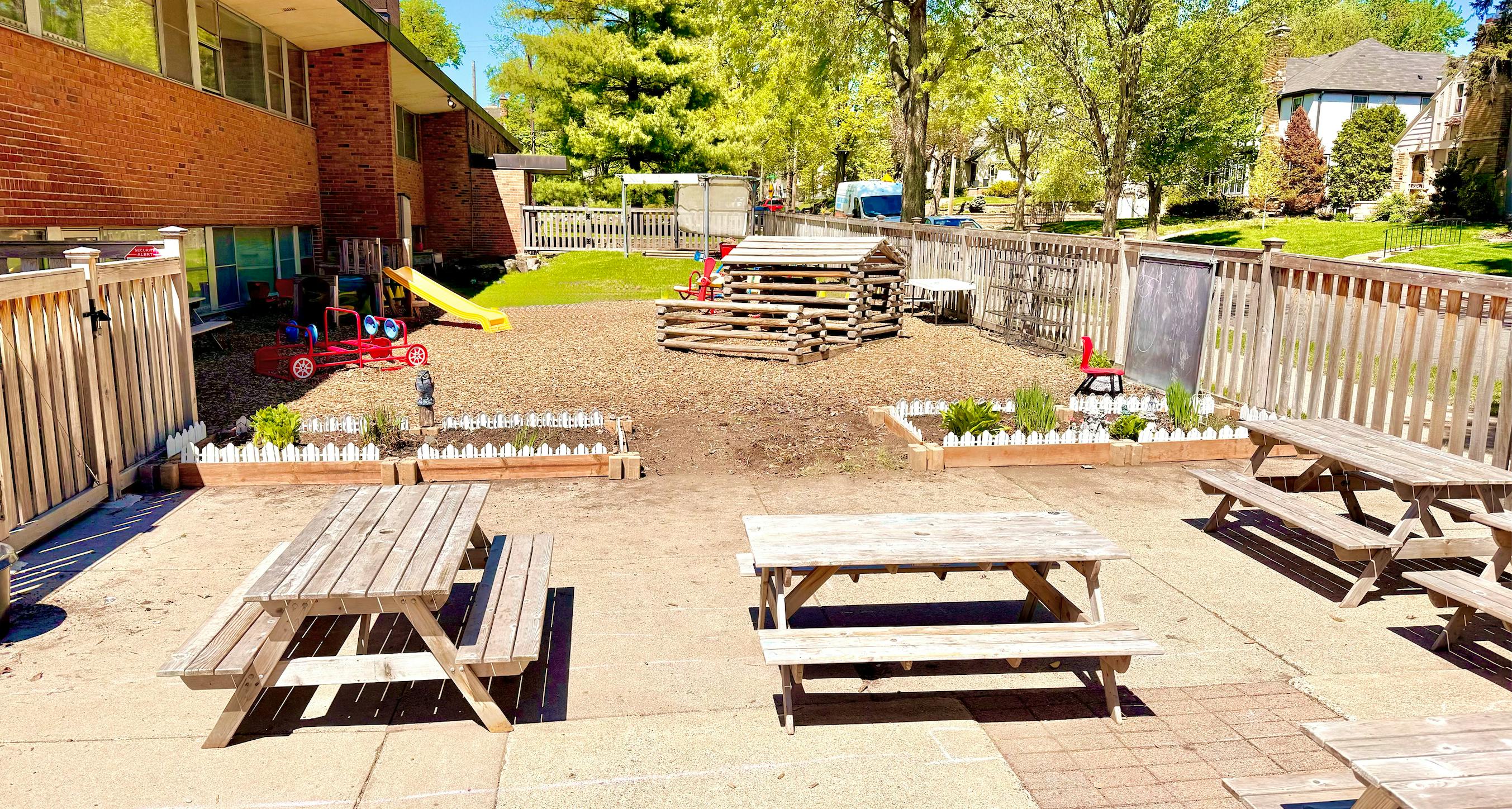 Outdoor children's play area with playground equipment and picnic tables