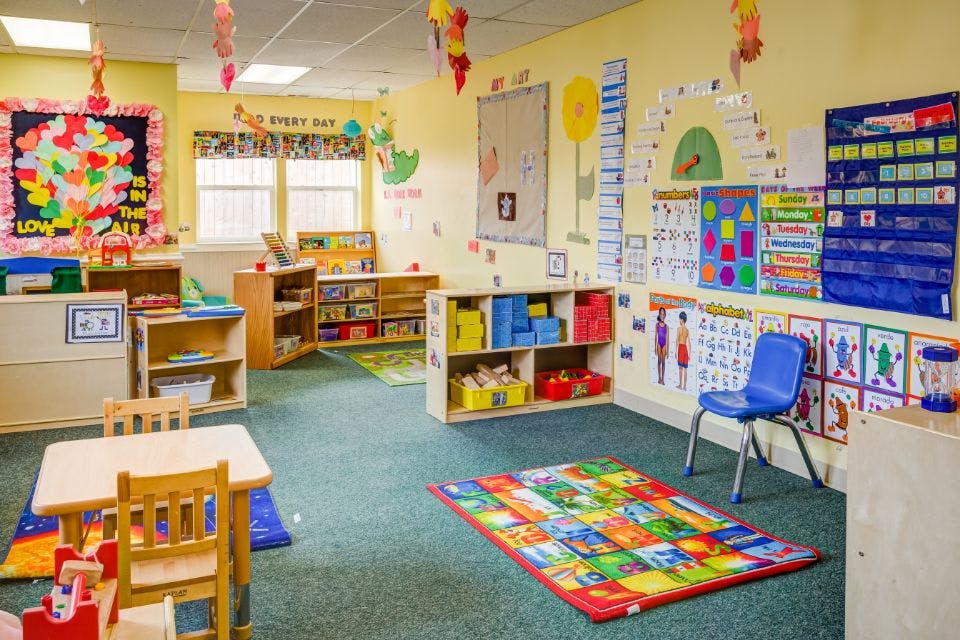Empty classroom with small tables, chairs, and colorful decorations