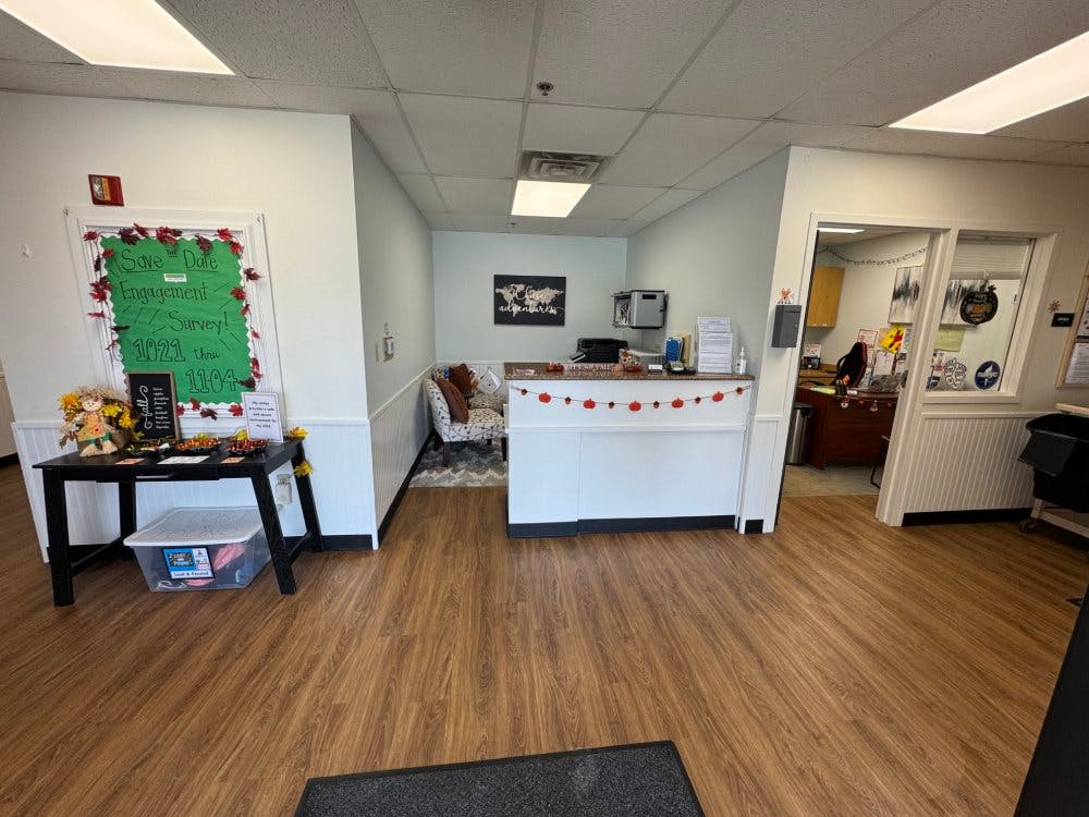 Reception area with a counter, a door with a sign, and a sitting area