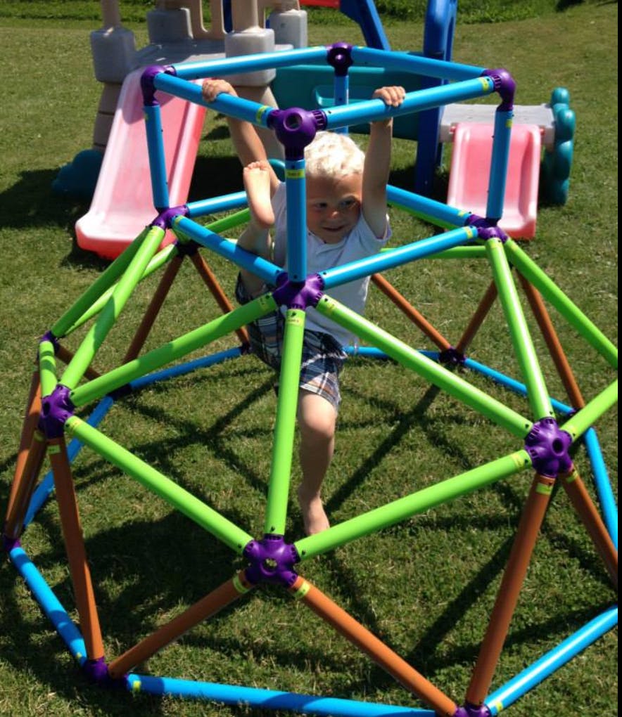 Child climbing on a colorful geometric dome climber