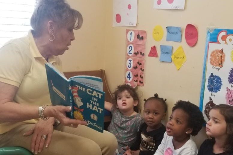 Person reading "The Cat in the Hat" to a group of children