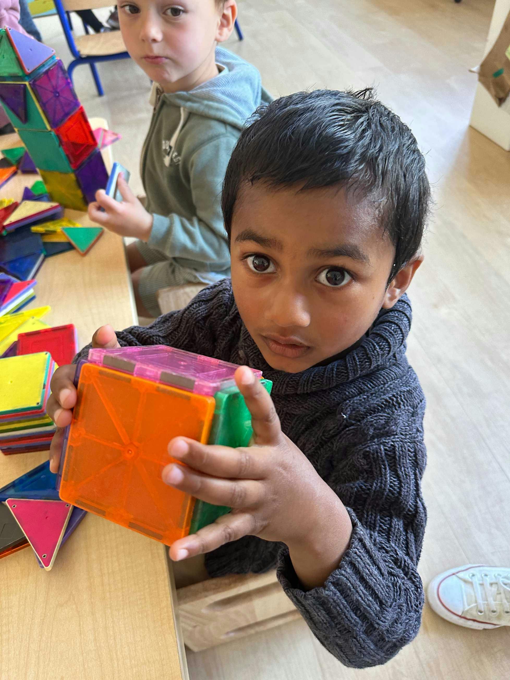 Child holding colorful magnetic building blocks