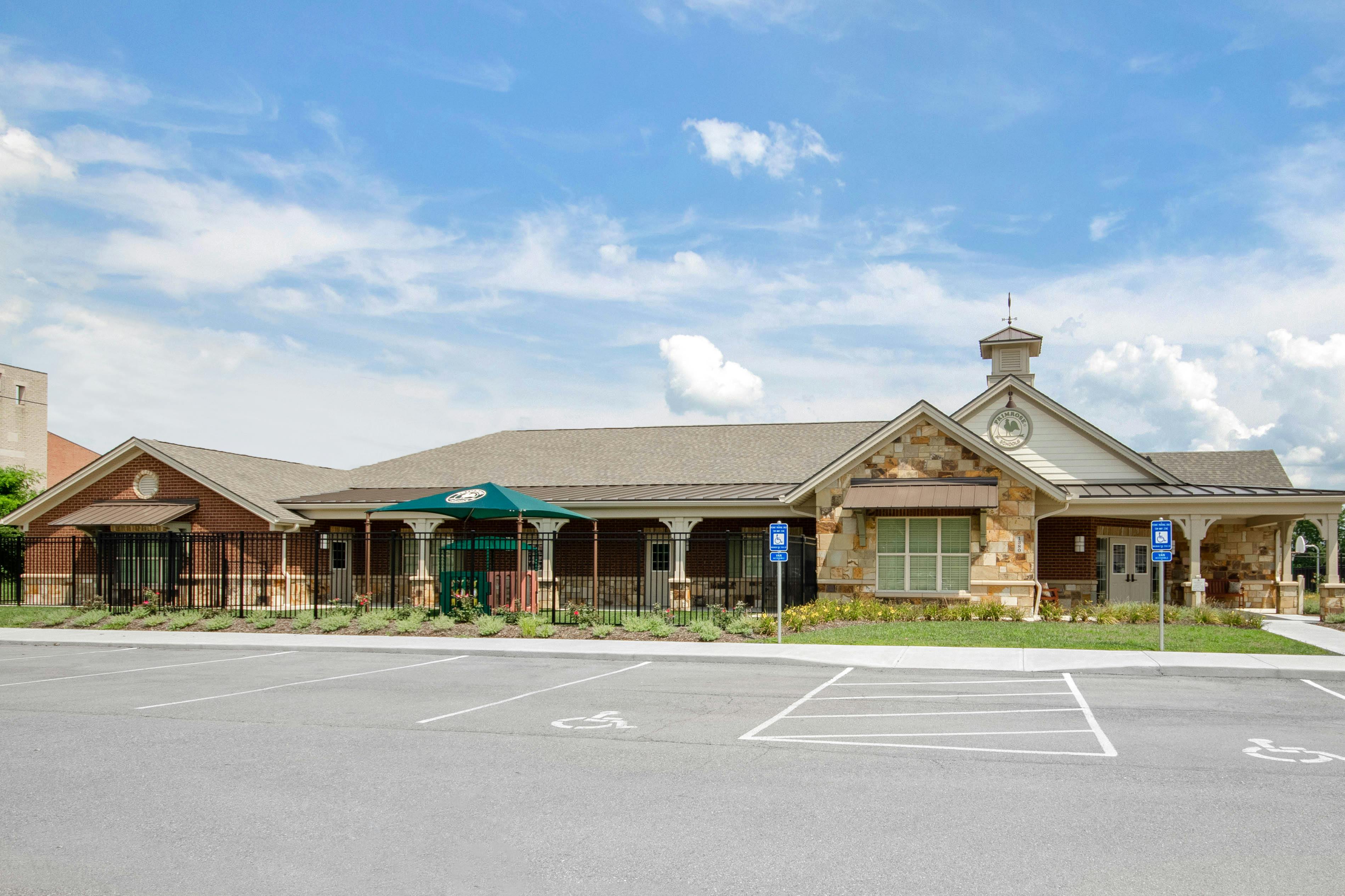 Exterior view of a Primrose Schools building with a parking lot in front
