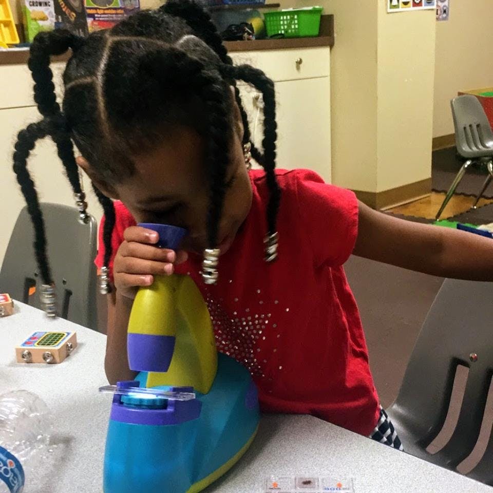 Child looking into a microscope
