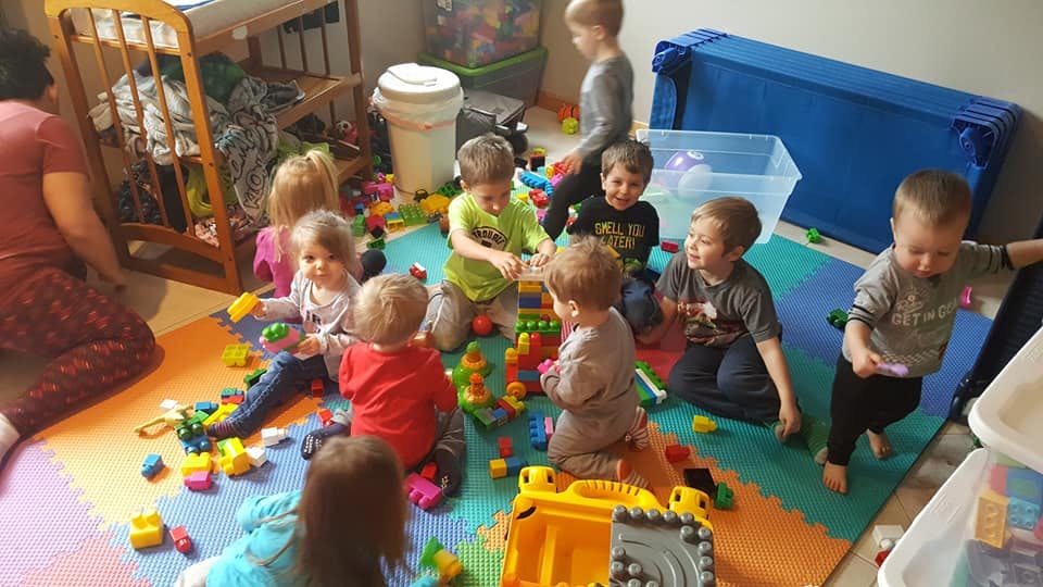 Children playing with building blocks on a colorful mat