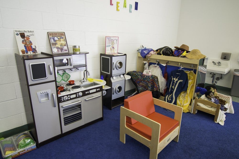 Play kitchen, washer and dryer, and dress-up clothes in a classroom
