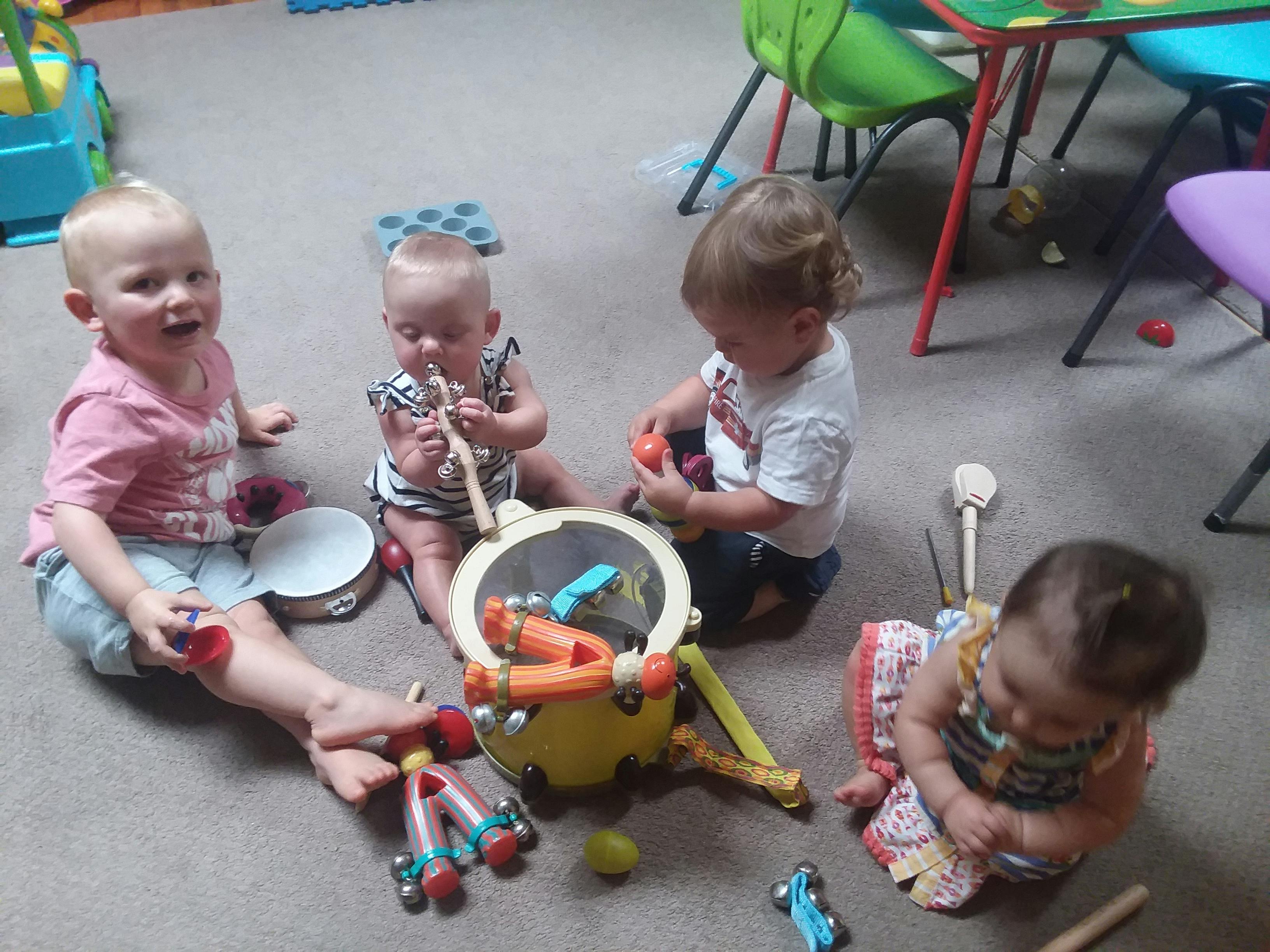 Four children playing with toys on the floor