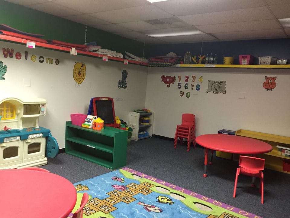 Playroom with small tables, chairs, and toys