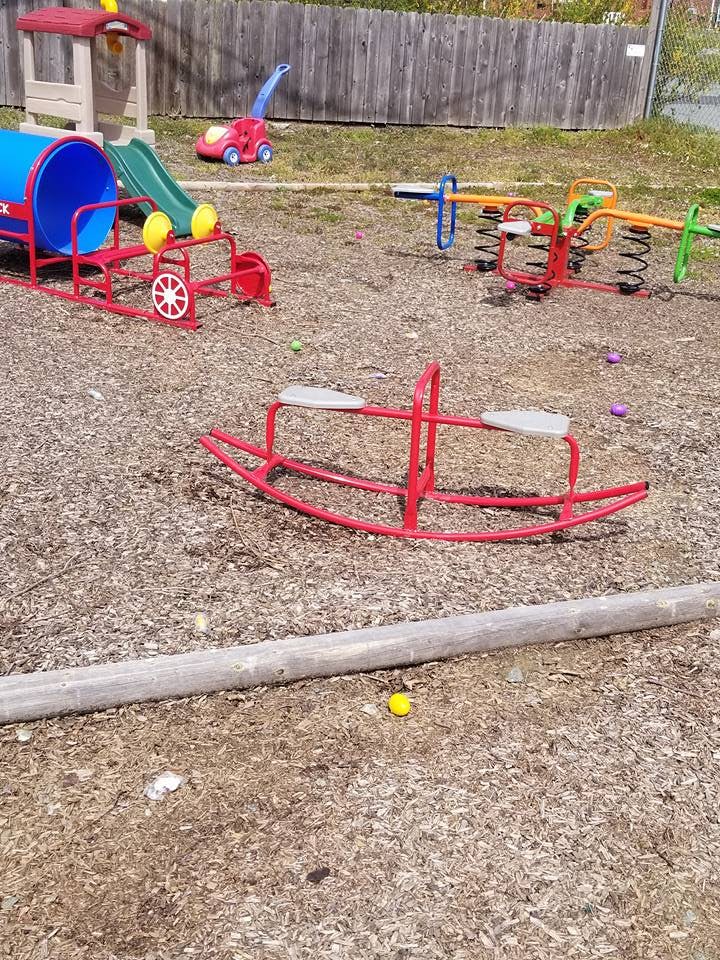 Playground with red and blue tunnel slide, red seesaw, and spring riders