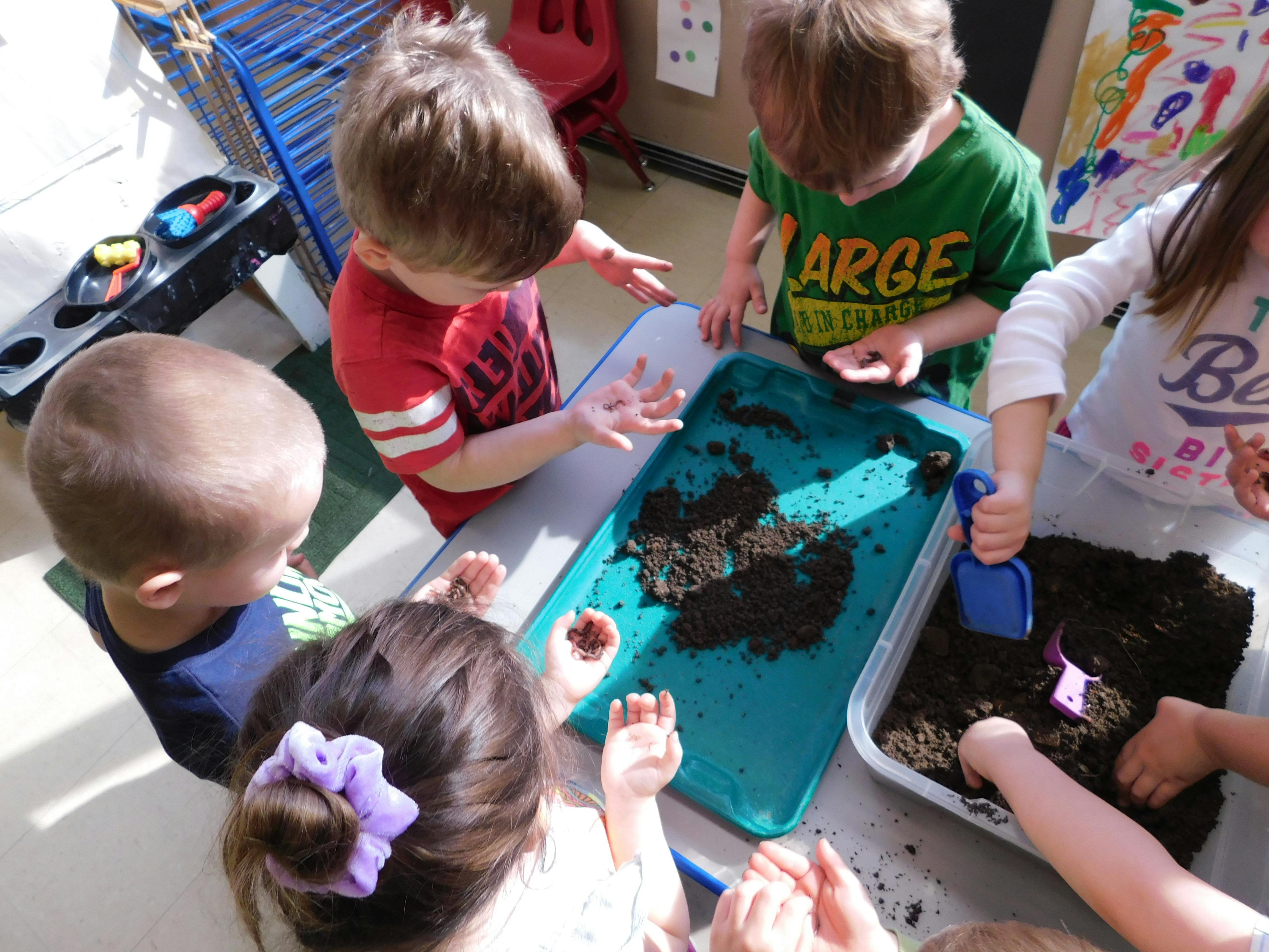 Children playing with dirt at a table
