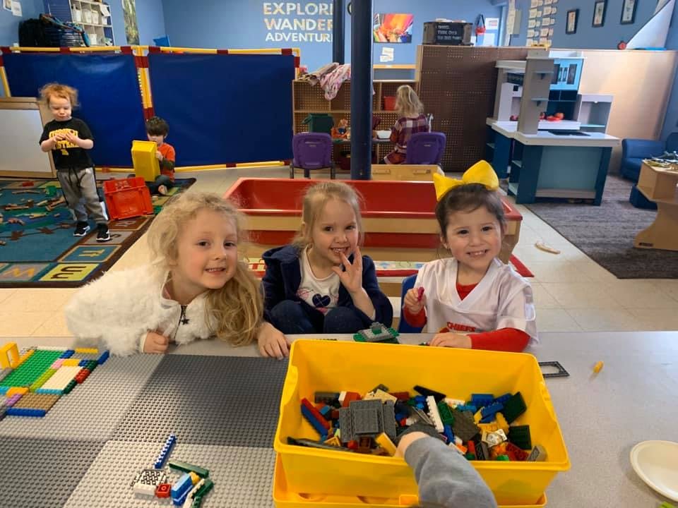 Three children at a table with building blocks
